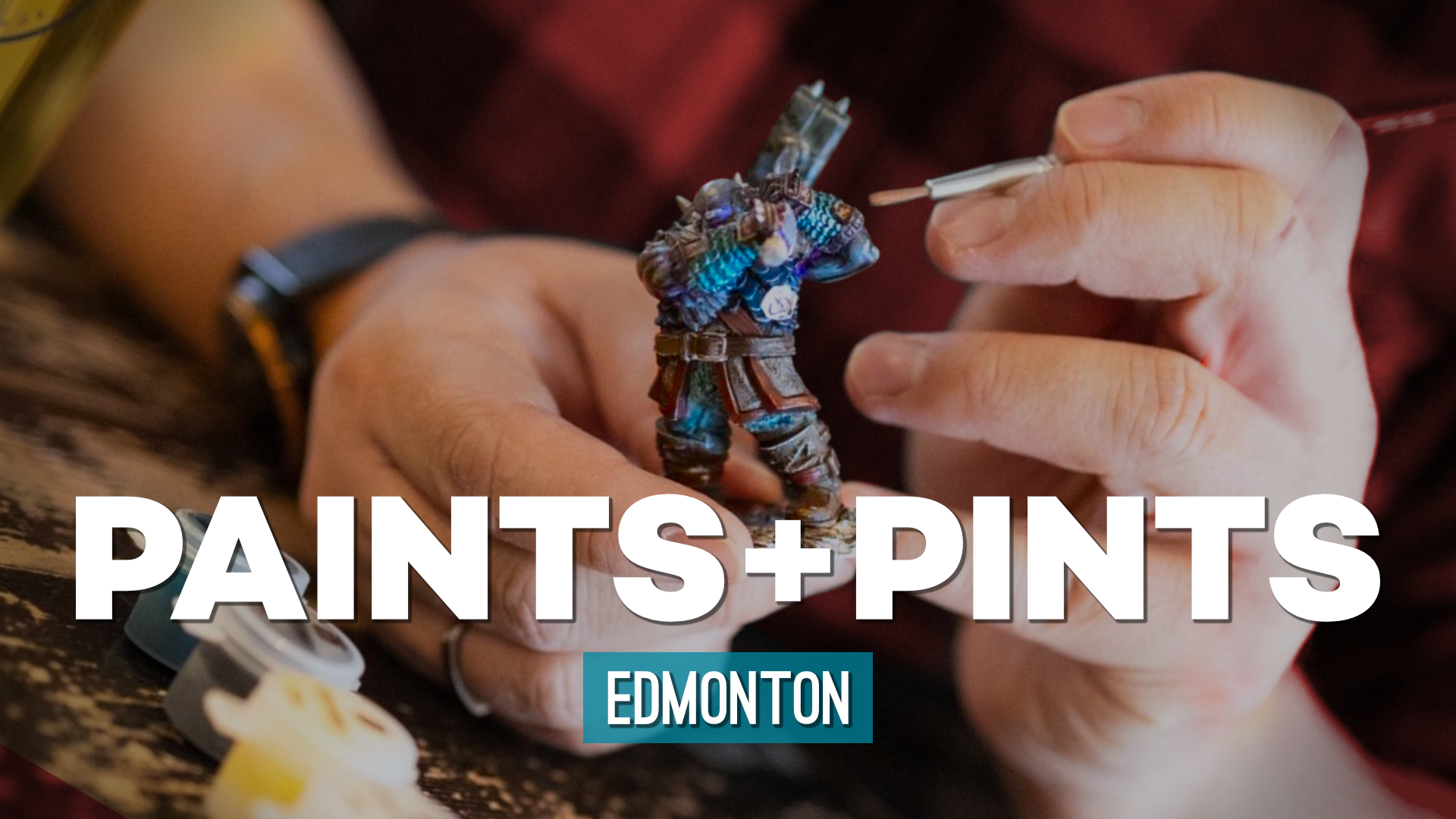 Someone holding and painting a miniature during a Paints and Pints event at the Hexagon Board Game Cafe.